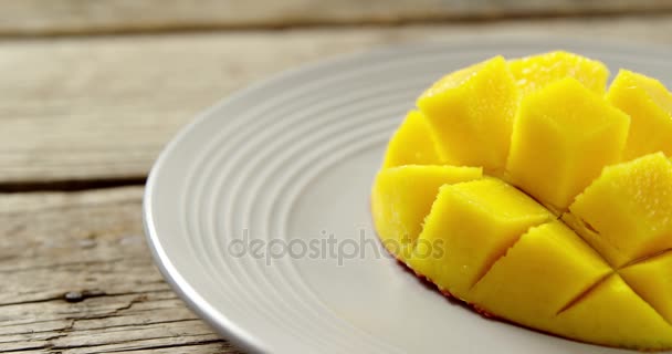 Gehakte mango's in plaat op houten tafel — Stockvideo