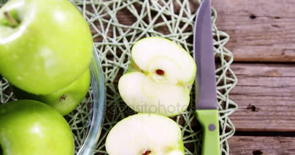 Manzanas verdes y cuchillo sobre tabla de madera — Vídeo de stock