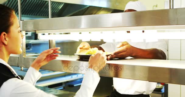 Chef entregando prato de comida para garçonete na estação de ordem — Vídeo de Stock