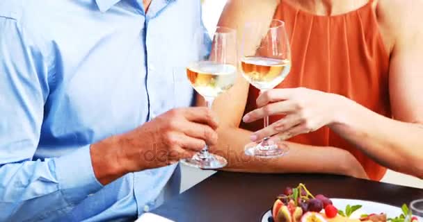 Ζευγάρι φρυγανίσματος ποτήρια κρασιού ενώ το γεύμα σε ένα εστιατόριο — Αρχείο Βίντεο