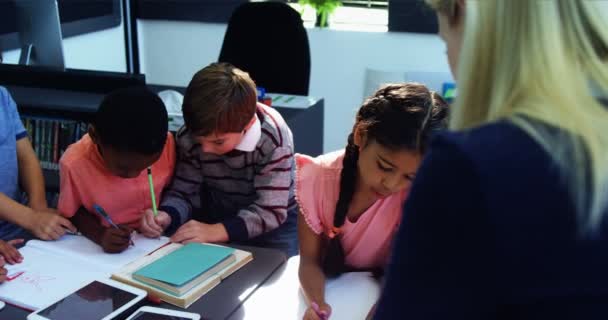 Teacher helping schoolgirl with her homework — Stock Video