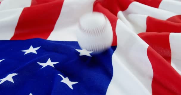 Béisbol cayendo sobre una bandera americana — Vídeos de Stock
