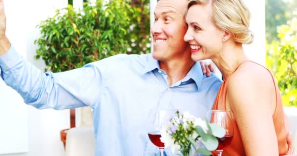 Pareja sonriente tomando selfie durante el almuerzo — Vídeos de Stock