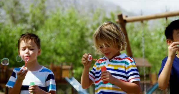 Estudantes brincando com varinha de bolha no playground — Vídeo de Stock