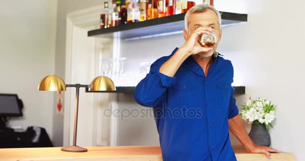 Ώριμος άνδρας πίνει κρασί ενώ στέκεται στο γκισέ — Αρχείο Βίντεο