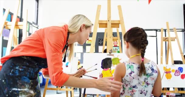 Teacher assisting girl in drawing class — Stock Video