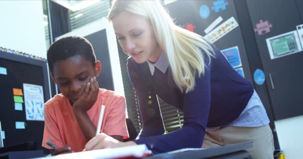 Teacher helping schoolboy with his homework — Stock Video