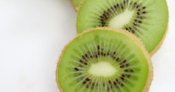 Kiwi-Scheiben auf weißem Hintergrund — Stockvideo