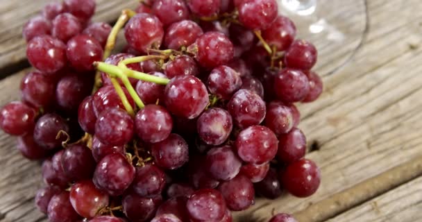 Виноград и красное вино на деревянной доске — стоковое видео
