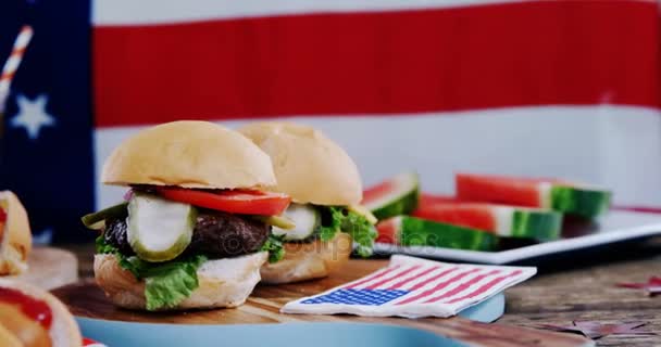 Hot dog i hamburger podawane na stół z 4 lipca tematu — Wideo stockowe