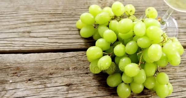 Uvas y vino blanco sobre tabla de madera — Vídeos de Stock