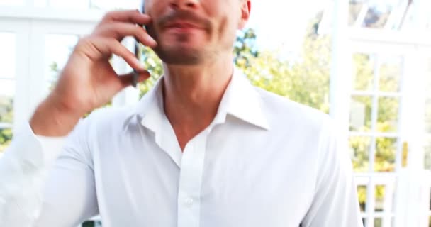 Красивый мужчина разговаривает по мобильному телефону — стоковое видео