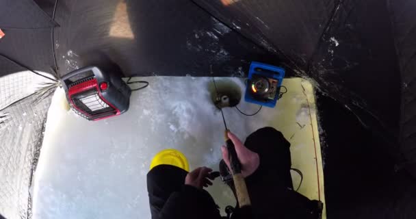 Чоловік готується до льодового рибальства в сніжному регіоні — стокове відео