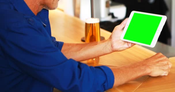 Hombre maduro usando tableta digital mientras toma cerveza — Vídeo de stock