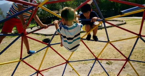 Schoolkinderen spelen op koepel klimmer in Speeltuin — Stockvideo