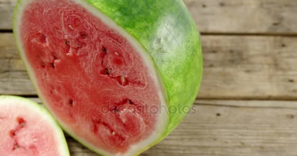 Plakjes en gehalveerd van watermeloen op houten tafel — Stockvideo