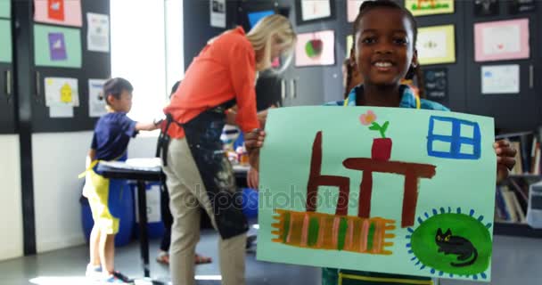 Счастливая девочка показывает свою картину на уроке рисования — стоковое видео