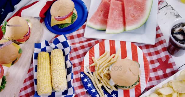 Hamburguesas y papas fritas servidas en la mesa — Vídeo de stock