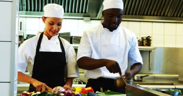 Chefs preparando alimentos na cozinha comercial — Vídeo de Stock