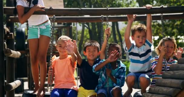 Mutlu schoolkids sallayarak portre oyun alanında eller — Stok video