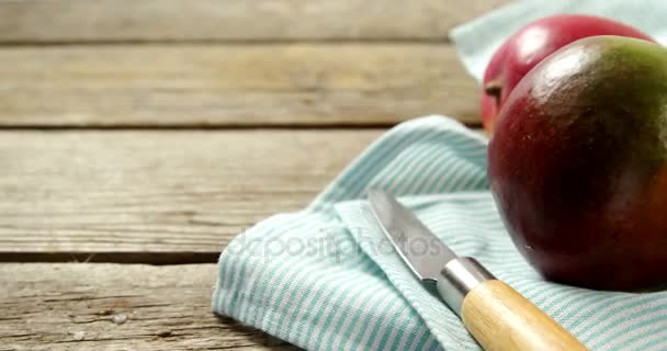 Mango con cuchillo sobre mesa de madera — Vídeos de Stock