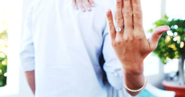 Женщина смотрит на обручальное кольцо, обнимая мужчину — стоковое видео