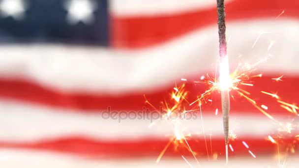 Спарклер горит на фоне американского флага — стоковое видео