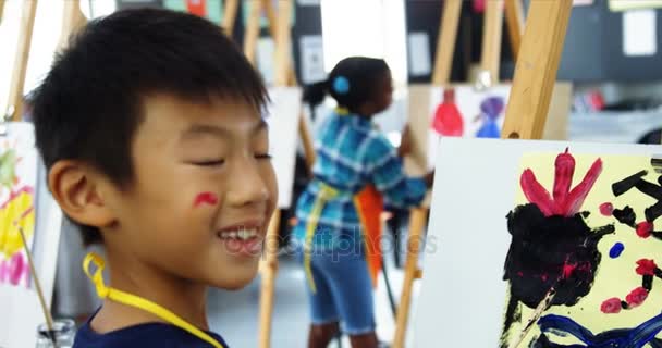Portret van schooljongen hijgen op doek tijdens het tekenen van de klasse — Stockvideo
