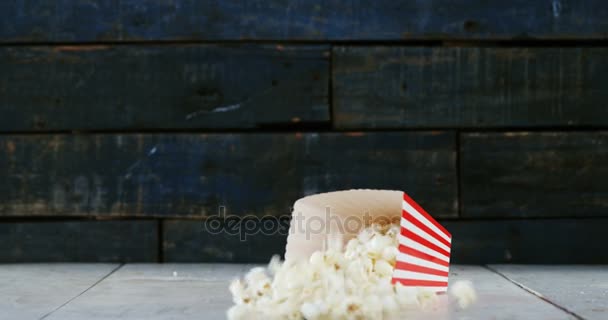 Popcorns πέφτουν στο ξύλινο τραπέζι — Αρχείο Βίντεο