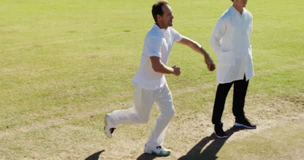 Боулер доставляет мяч во время матча по крикету — стоковое видео