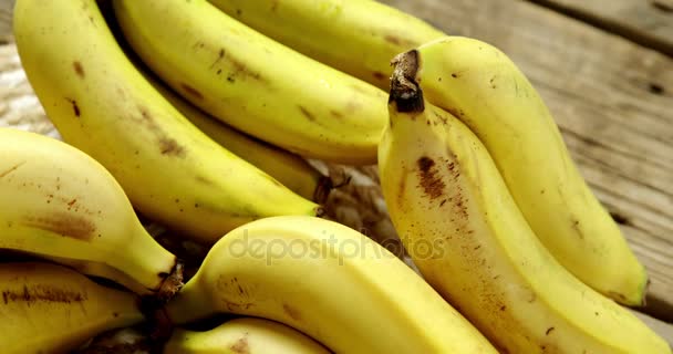 Свежие бананы на деревянной доске — стоковое видео