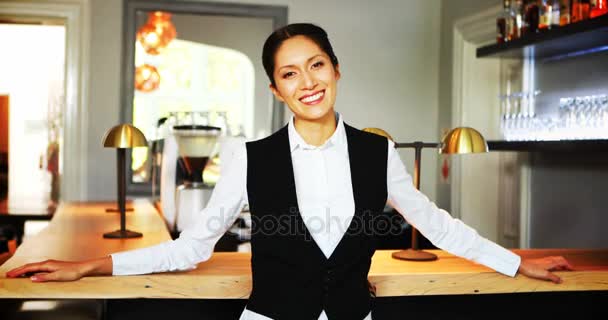 Улыбающаяся официантка, стоящая за прилавком — стоковое видео
