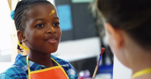 Школьники взаимодействуют друг с другом во время урока рисования — стоковое видео