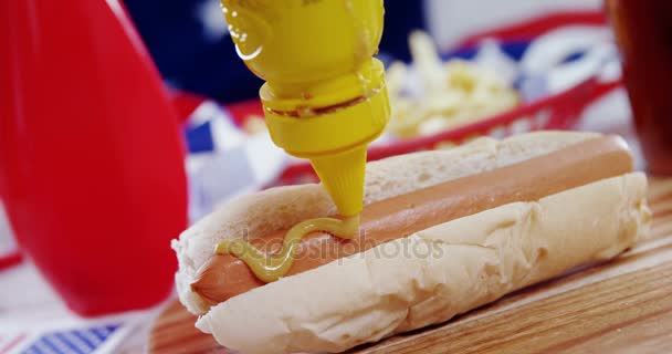 Hot dog με σάλτσα μουστάρδας στην ξύλινη σανίδα — Αρχείο Βίντεο