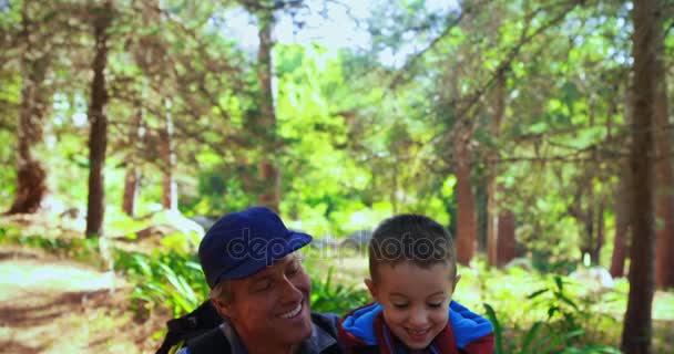 Père aidant son fils à utiliser le téléphone portable dans le parc — Video