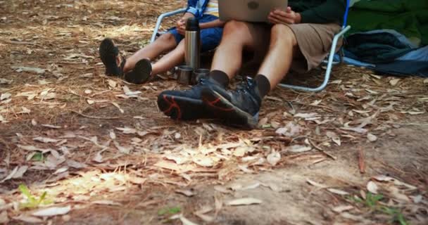 Pai e filho usando laptop fora da tenda — Vídeo de Stock