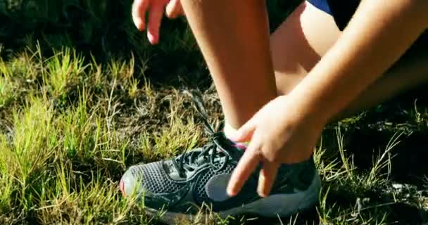 Chica atando sus cordones de zapatos — Vídeo de stock