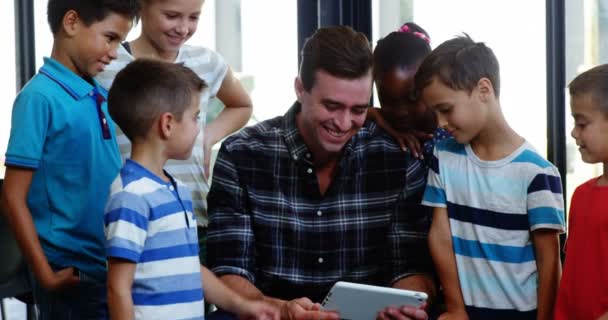 Profesor y niños usando tableta en el aula — Vídeo de stock