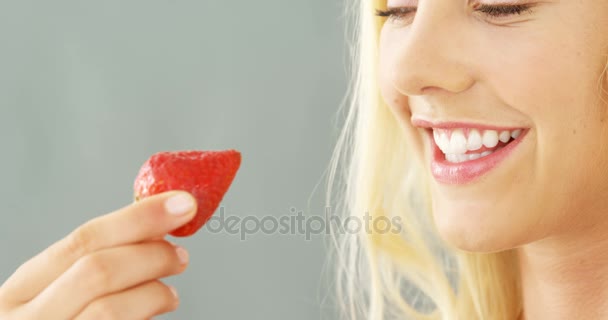 Close-up van de mooie vrouw eten aardbeien in kom — Stockvideo
