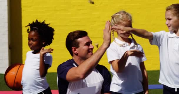 Los niños de la escuela dando cinco a entrenador — Vídeo de stock