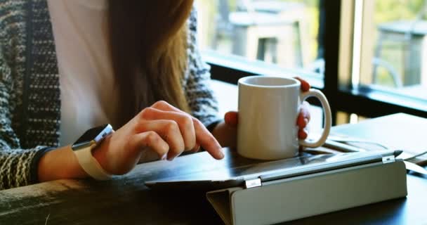 Mulher tomando café ao usar no telefone móvel — Vídeo de Stock