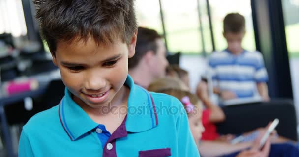 Portrait of happy schoolboy smiling in classroom — Stock Video