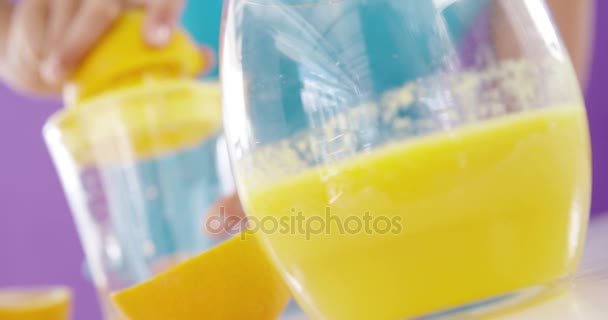 Kvinna som förbereder söta limejuice från juicer mot lila bakgrund — Stockvideo