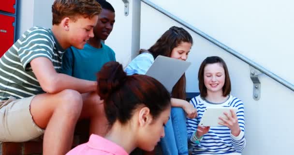ノート パソコンとデジタル タブレットを使用して階段の上の学校の友達を笑顔のグループ — ストック動画