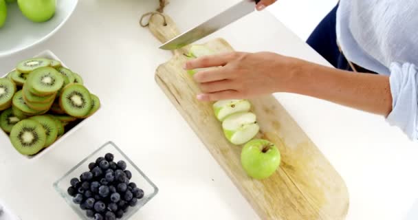 Vrouw snijden van groene appel op hakken bestuur — Stockvideo