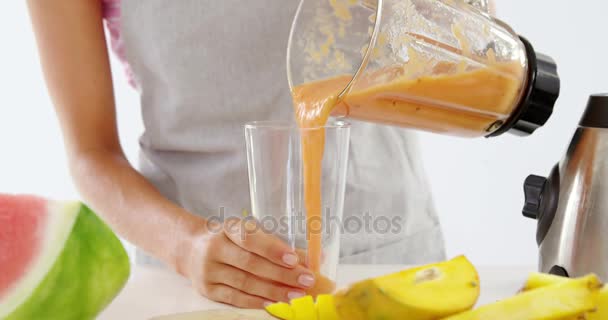Meados de seção de mulher derramando smoothie em vidro — Vídeo de Stock