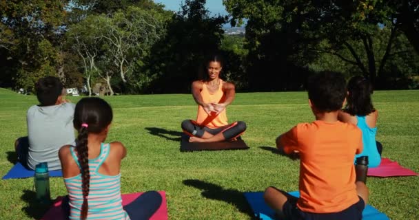 Yoga-instructeur instrueren van kinderen bij het uitvoeren van de oefening — Stockvideo