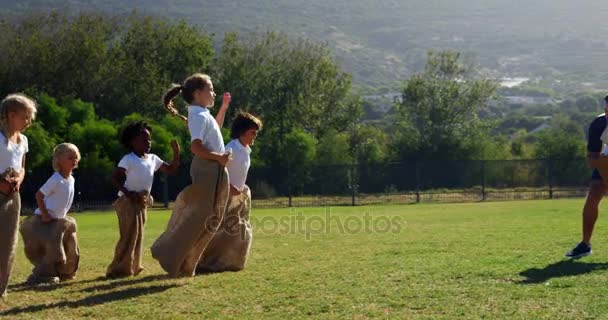 Barn som leker en sack race i park — Stockvideo