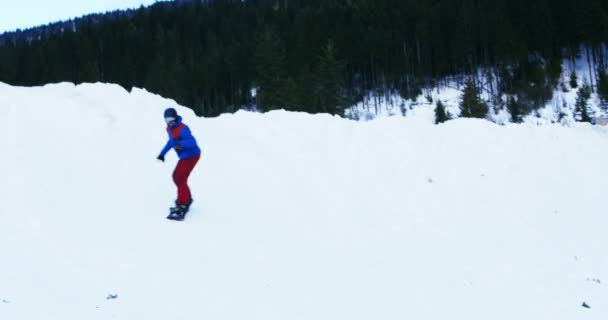 Osoba na snowboardzie na ośnieżonych górskich — Wideo stockowe