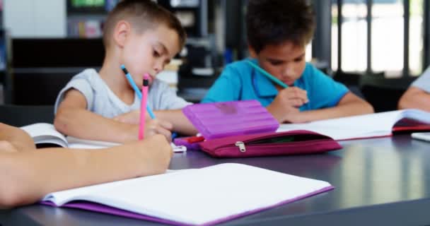 Niños de la escuela haciendo deberes en el aula — Vídeos de Stock